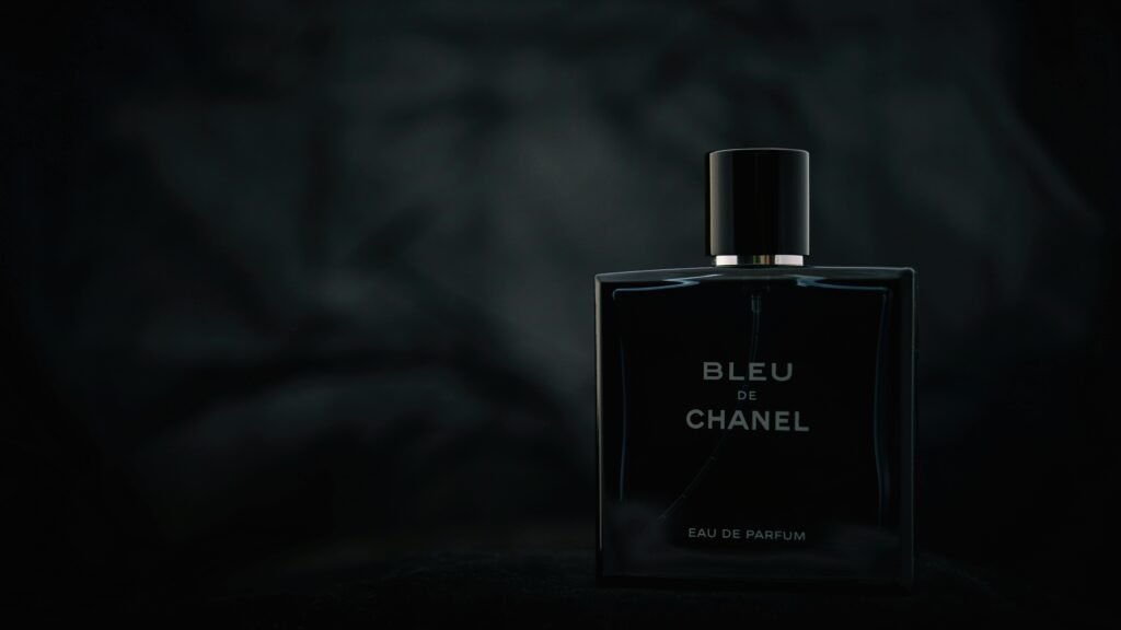 Close-up of Bleu de Chanel perfume bottle on a dark background, showcasing elegant product design.