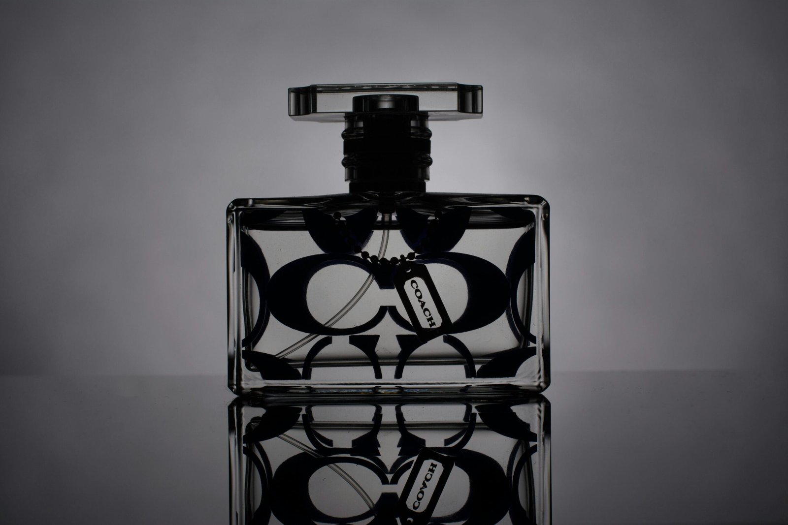 Artistic black and white shot of a designer perfume bottle with reflection.